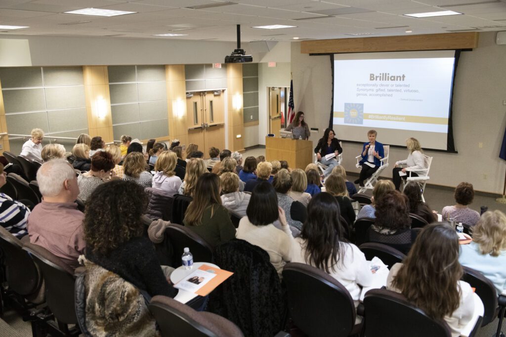 kristin and mary fran speaking ot an auditorium filled with people